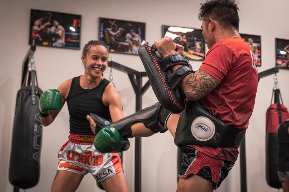 ACSA coach in red holding pads for a student during a one-on-one Muay Thai personal training session in Thornbury, Melbourne